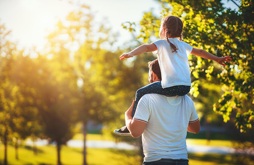 Father carrying daughter on his back during family outing at Valencia